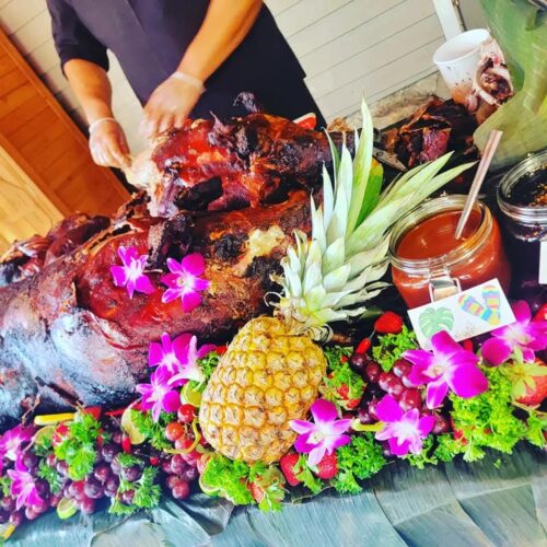 a large roasted pig with flowers and fruits 